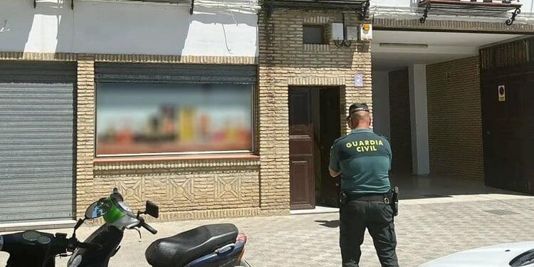 Efectivo de la Guardia Civil delante del portal de la vivienda donde ha sido hallada la joven fallecida | Utrera Digital